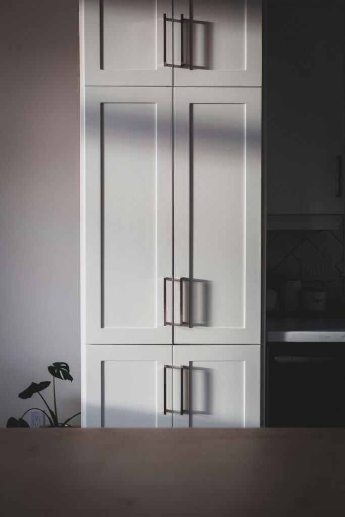 Contemporary kitchen cabinet with clean lines and sunlight shadows, perfect for modern interiors.